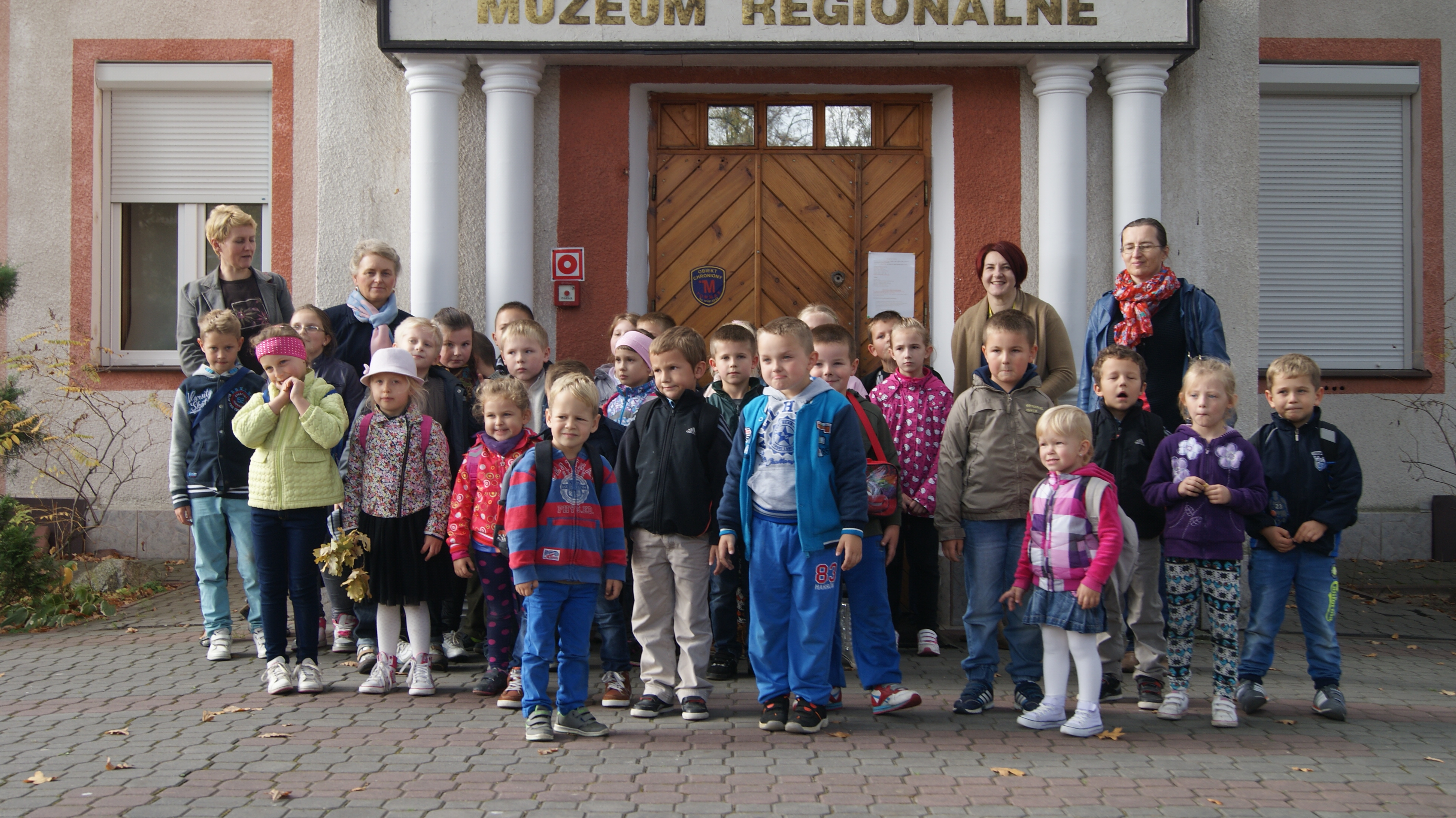 Grupa uczestników warsztatów przed budynkiem głównym muzeum